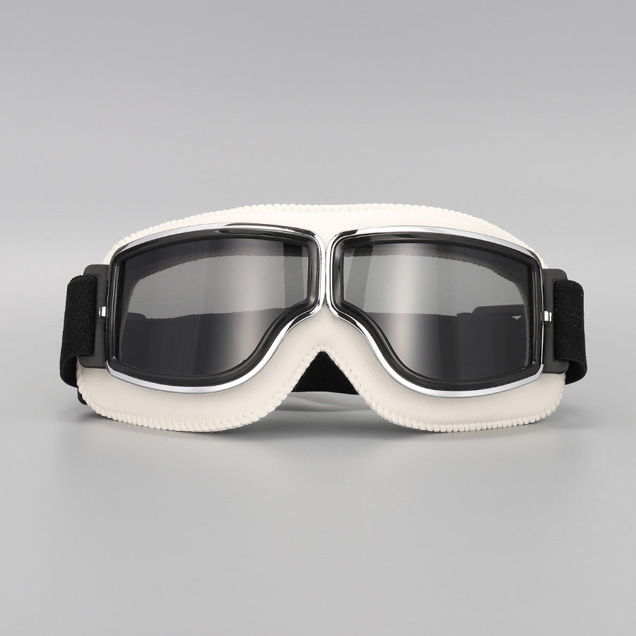 Front view of the cream-white padded goggles with chrome trim and smoky grey tinted lenses. 14