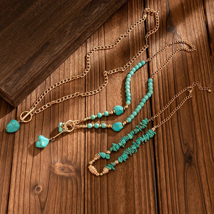 All three necklaces laid out separately on wood: chip choker, beaded strand and long chain with stone drop 7