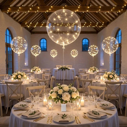 Glowing clear balloons above round tables with white flowers in a rustic wedding barn 5