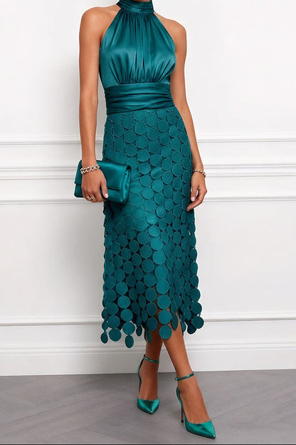 Model wears the halter midi dress in deep teal green with a ruched satin bodice, disc appliqué skirt and matching clutch and heels. 6