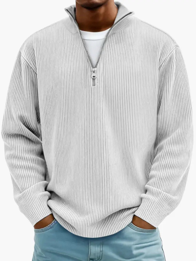 Man wearing the ribbed quarter-zip jumper in pale grey over a white tee, hands in the pockets of light blue jeans. 6