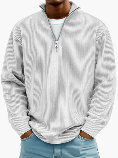 Man wearing the ribbed quarter-zip jumper in pale grey over a white tee, hands in the pockets of light blue jeans. 6