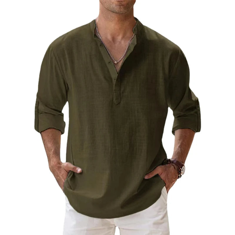 Man wearing the Henley shirt in olive green, with a short button placket, rolled sleeves and hands in white trousers. 8