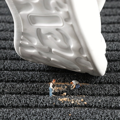 A white trainer sole hovers over the grey pile while tiny figures sweep up crumbs of dirt trapped in it. 4
