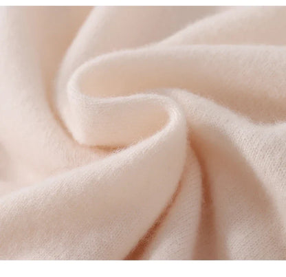 Close-up of soft cream knit fabric folded in a gentle swirl, showing its fuzzy texture 6