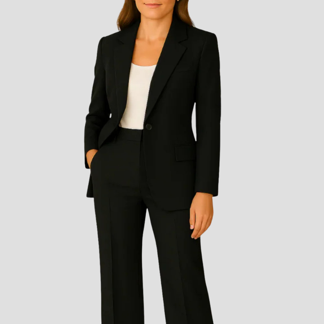 Model wearing the black suit with a white top, one hand in the trouser pocket 6