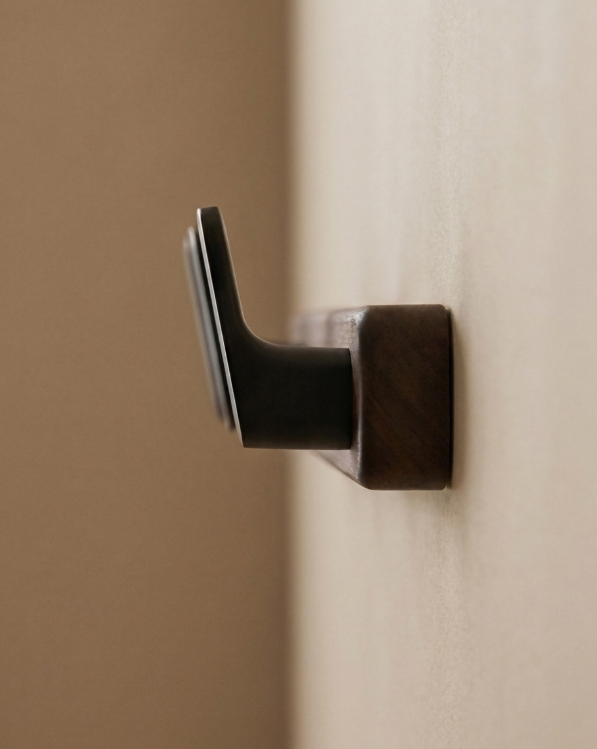 Side view of a black hook projecting from the wooden board fixed to the wall 5