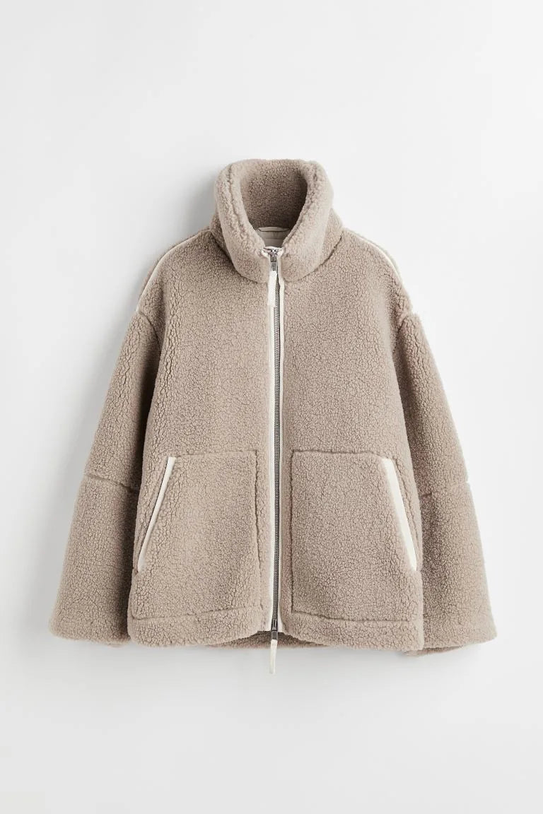 Beige fleece zip coat laid flat, showing the high collar, front pockets and cream trim 6