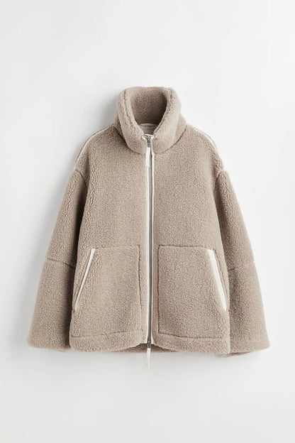 Beige fleece zip coat laid flat, showing the high collar, front pockets and cream trim 6