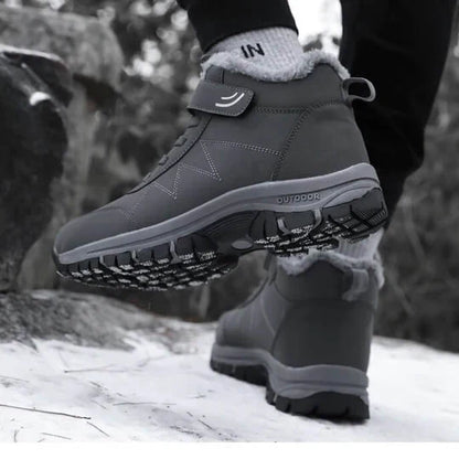 Person walking in grey fleece-lined boots on snow, one raised foot showing the patterned tread 8