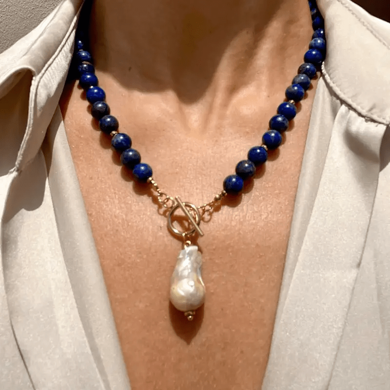 Necklace worn by a model over a cream blouse, with the toggle clasp at the front 1