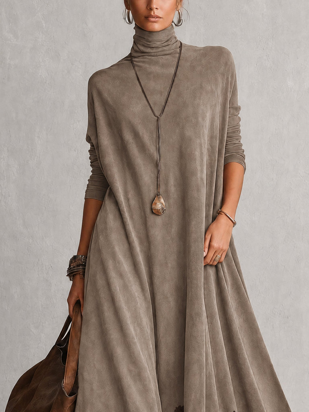 Close-up of the taupe dress's turtleneck and loose long-sleeved bodice, worn with a pendant necklace 13