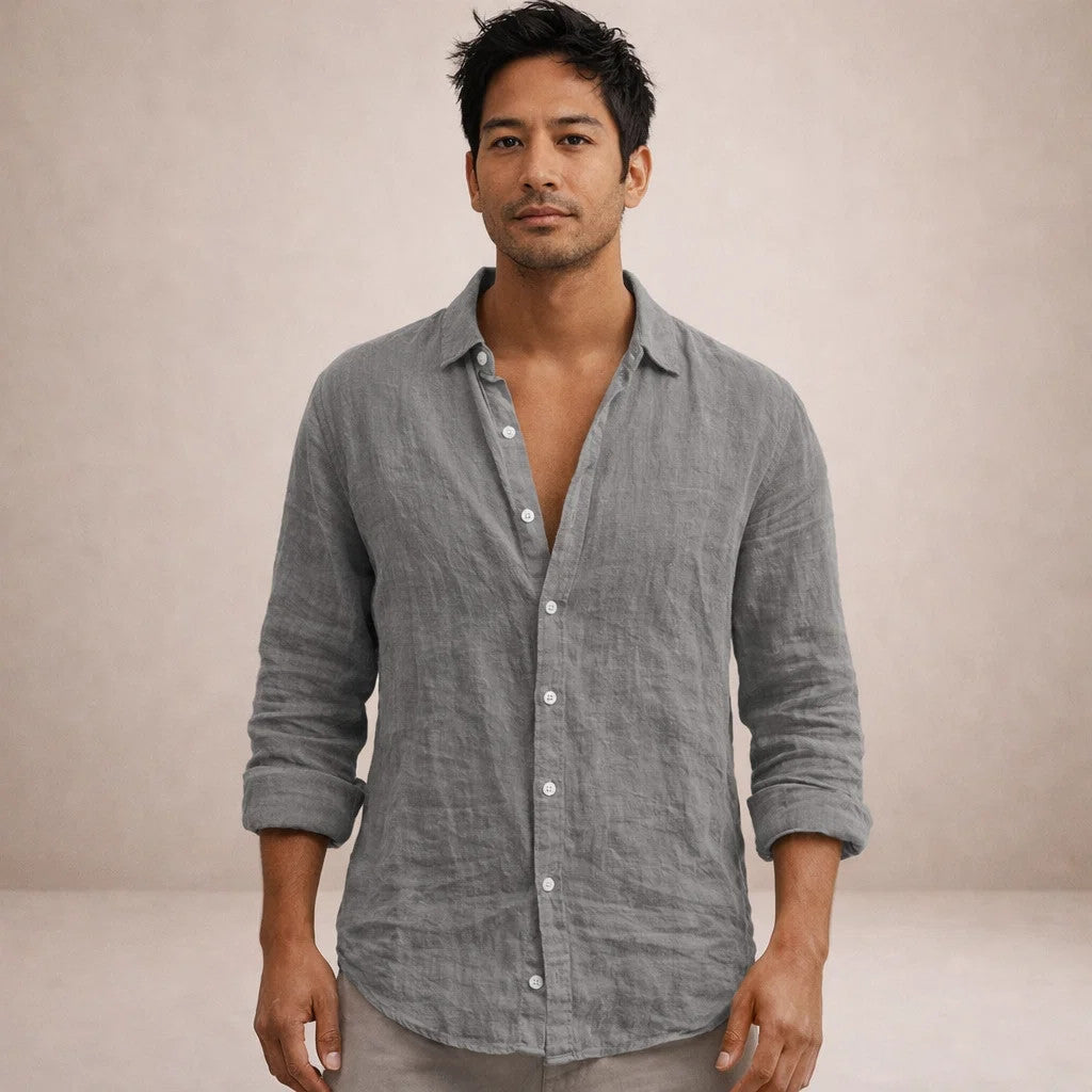 Model facing the camera in a grey linen shirt with a relaxed open collar and sleeves rolled to the forearms. 8