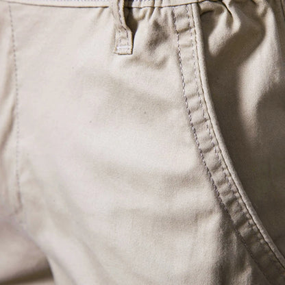 Close-up of the stitched side pocket opening and a belt loop on the beige cotton fabric. 3