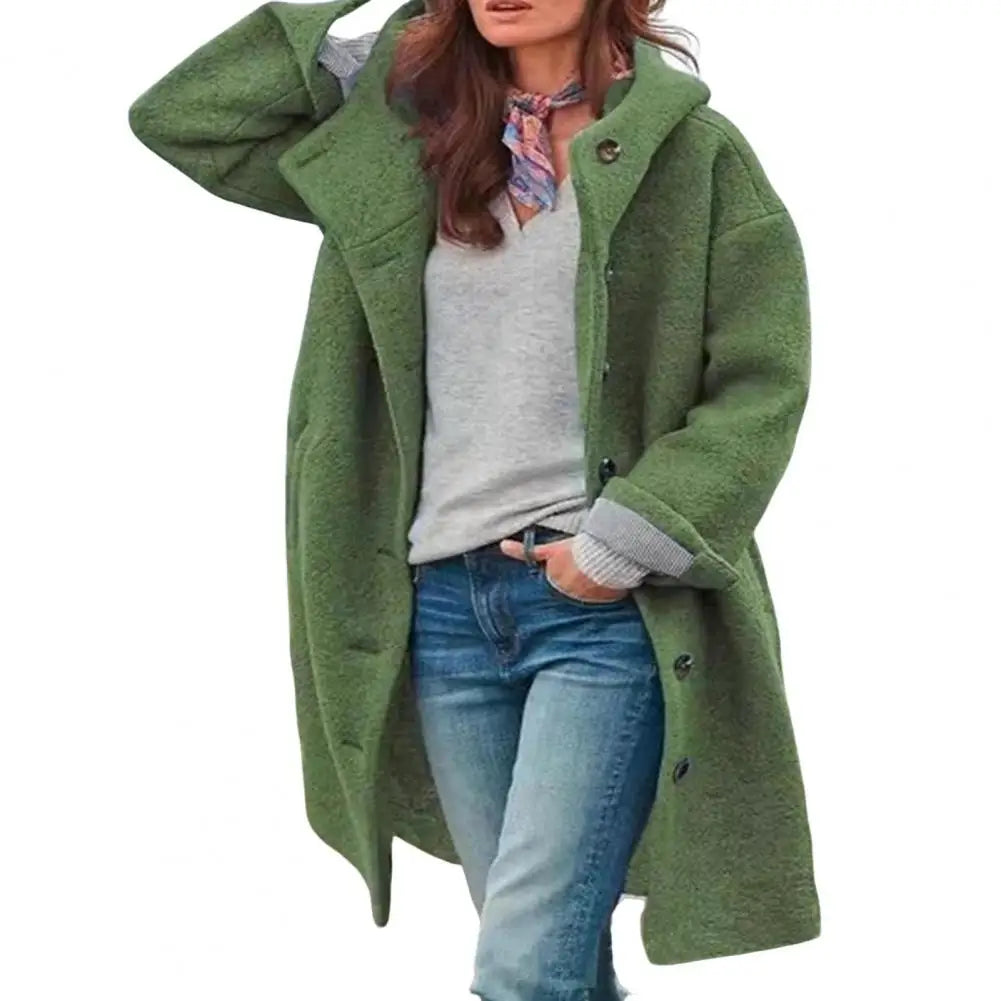 Green coat styled with a grey top, scarf and jeans, shown against a plain white background 7