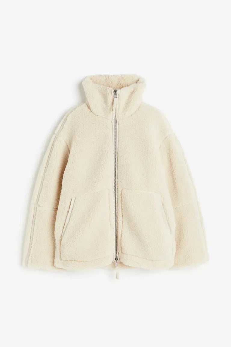 Cream fleece zip coat laid flat, showing the high collar, two-way zip and patch pockets 7