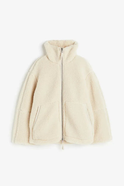 Cream fleece zip coat laid flat, showing the high collar, two-way zip and patch pockets 7