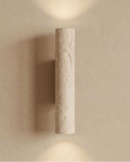 Front view of the lit travertine cylinder with light spreading above and below on the wall 7