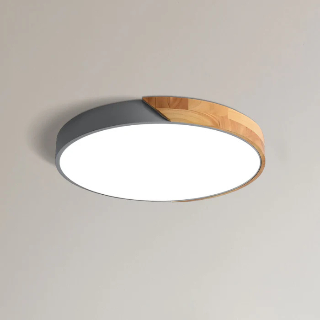Grey and wood round ceiling light shown close up on a plain ceiling, lit 8