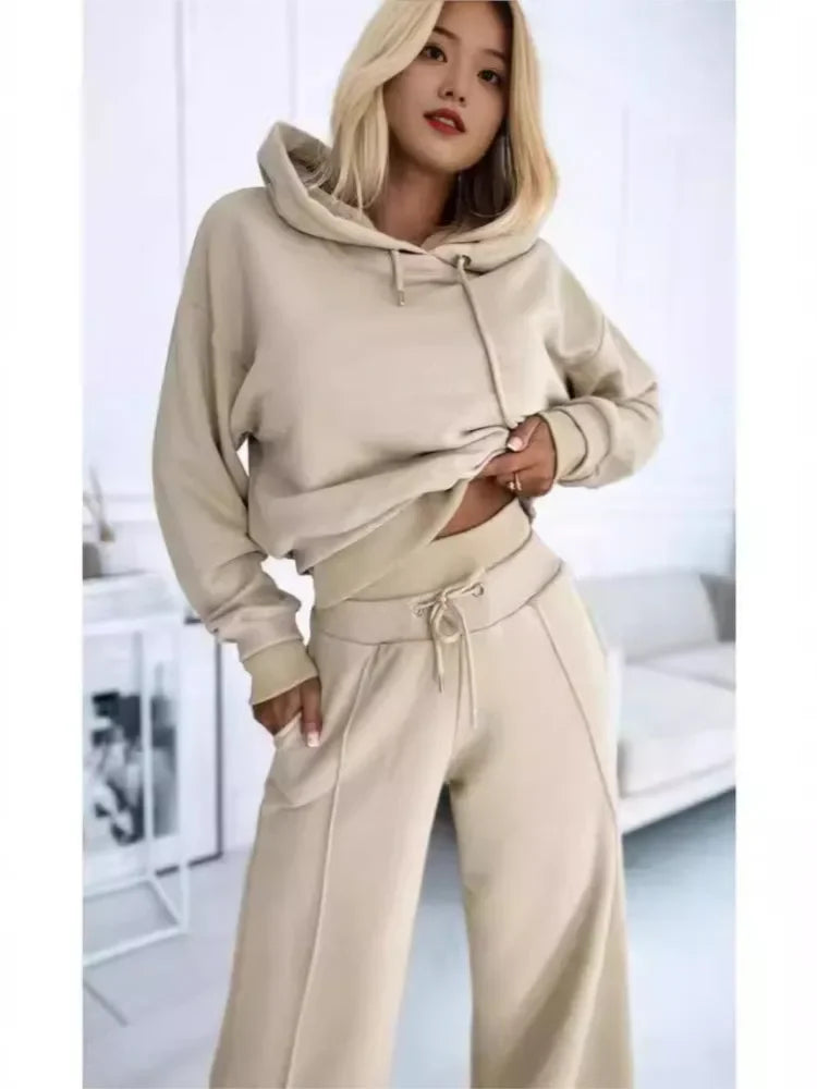 Close-up of the beige hooded set on a model, hand in pocket and drawstring waist visible 7