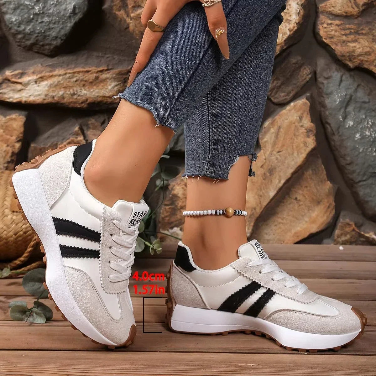 Cream and black striped trainers worn with jeans, with a marker showing the platform height of four centimetres 7