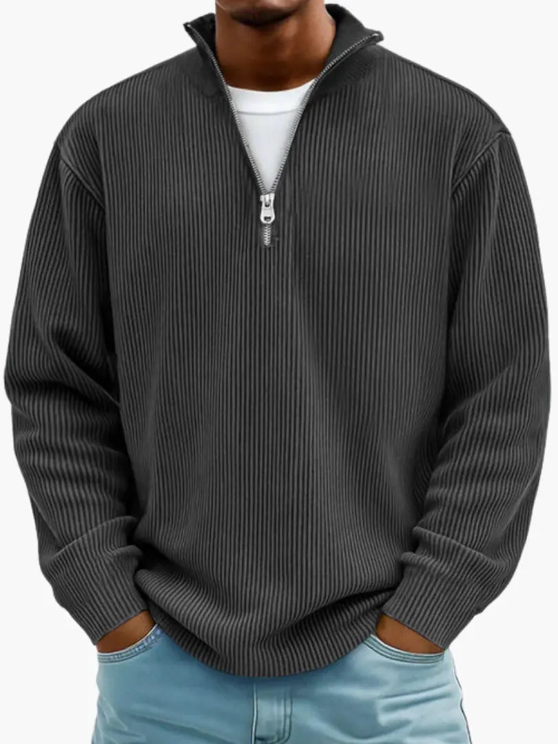 Man wearing the ribbed quarter-zip jumper in charcoal over a white tee, hands in the pockets of light blue jeans. 7
