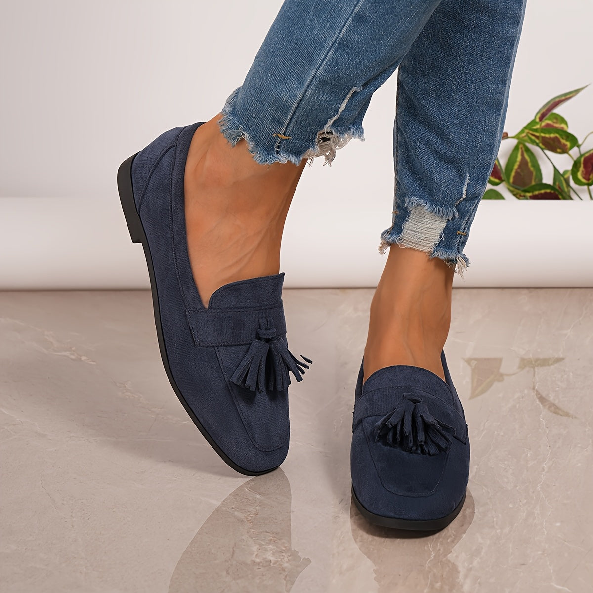 Navy tasselled loafers worn with ripped-hem jeans, seen from the side and front 3