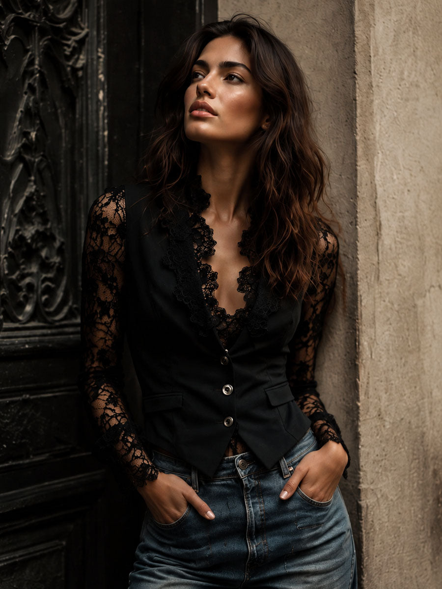 Model leaning against a textured wall wearing the black lace-sleeved waistcoat jacket with blue jeans 2