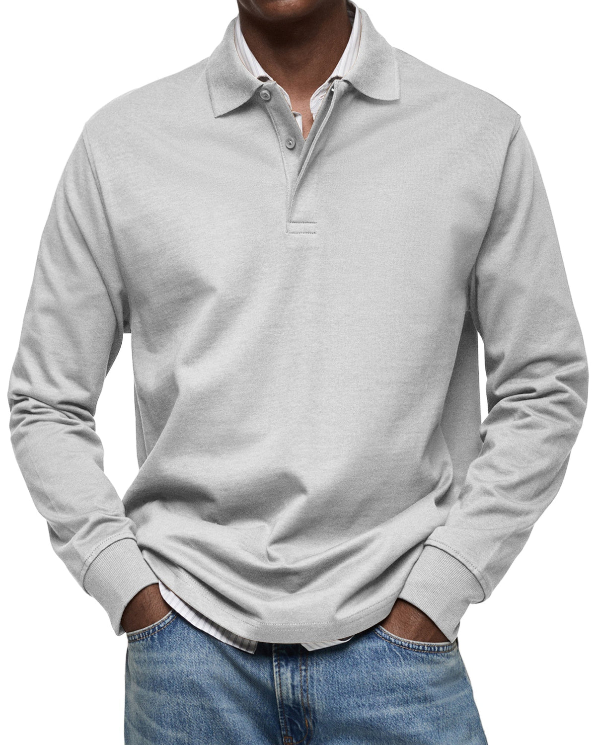 Front view of the polo in light grey on a model, hands in pockets, collar of a striped shirt showing beneath. 5