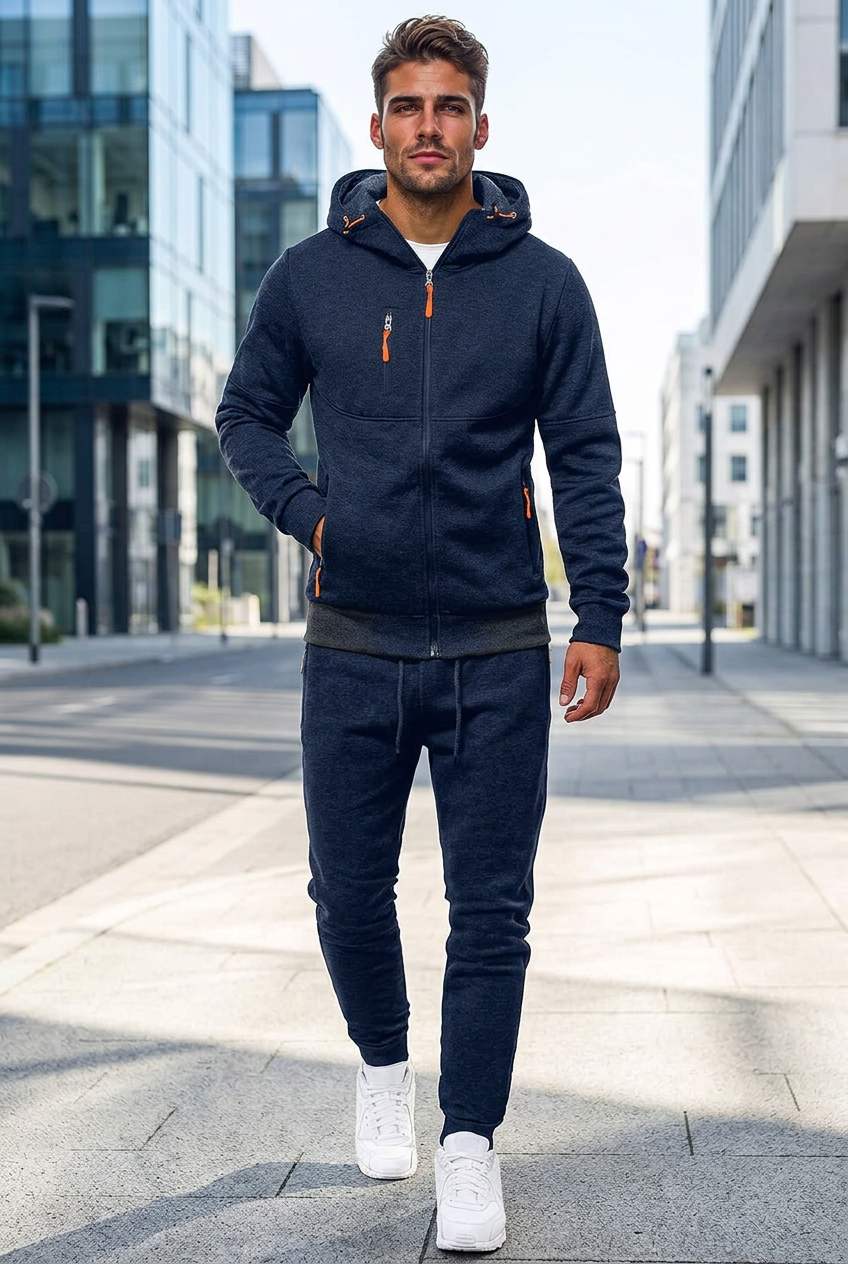 Model in navy zip-up hooded tracksuit with orange zip pulls, walking along a city street 1