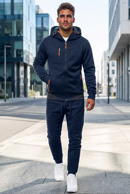 Model in navy zip-up hooded tracksuit with orange zip pulls, walking along a city street 1