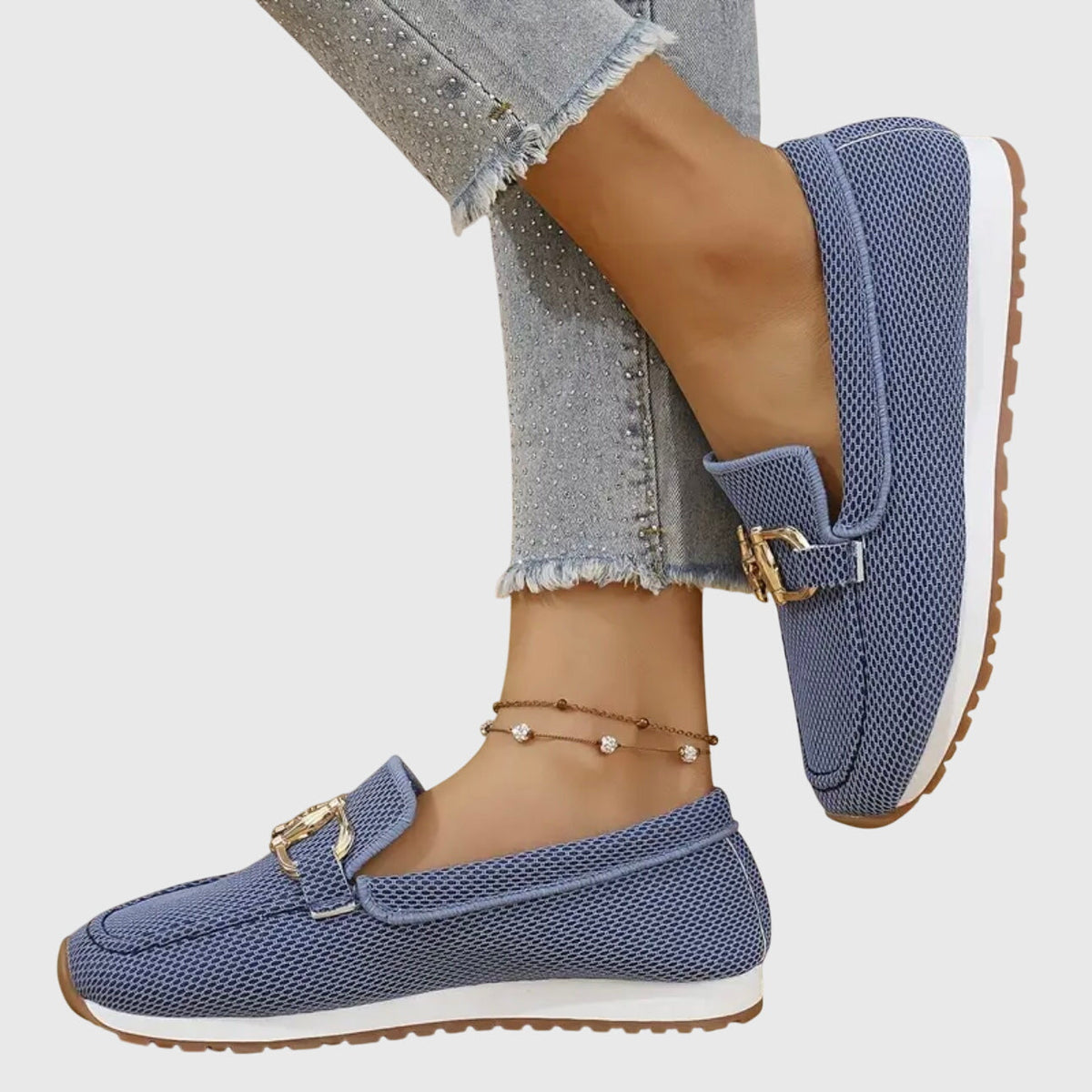 Blue mesh loafers worn with one foot raised, showing the side, buckle and tread of the sole 7