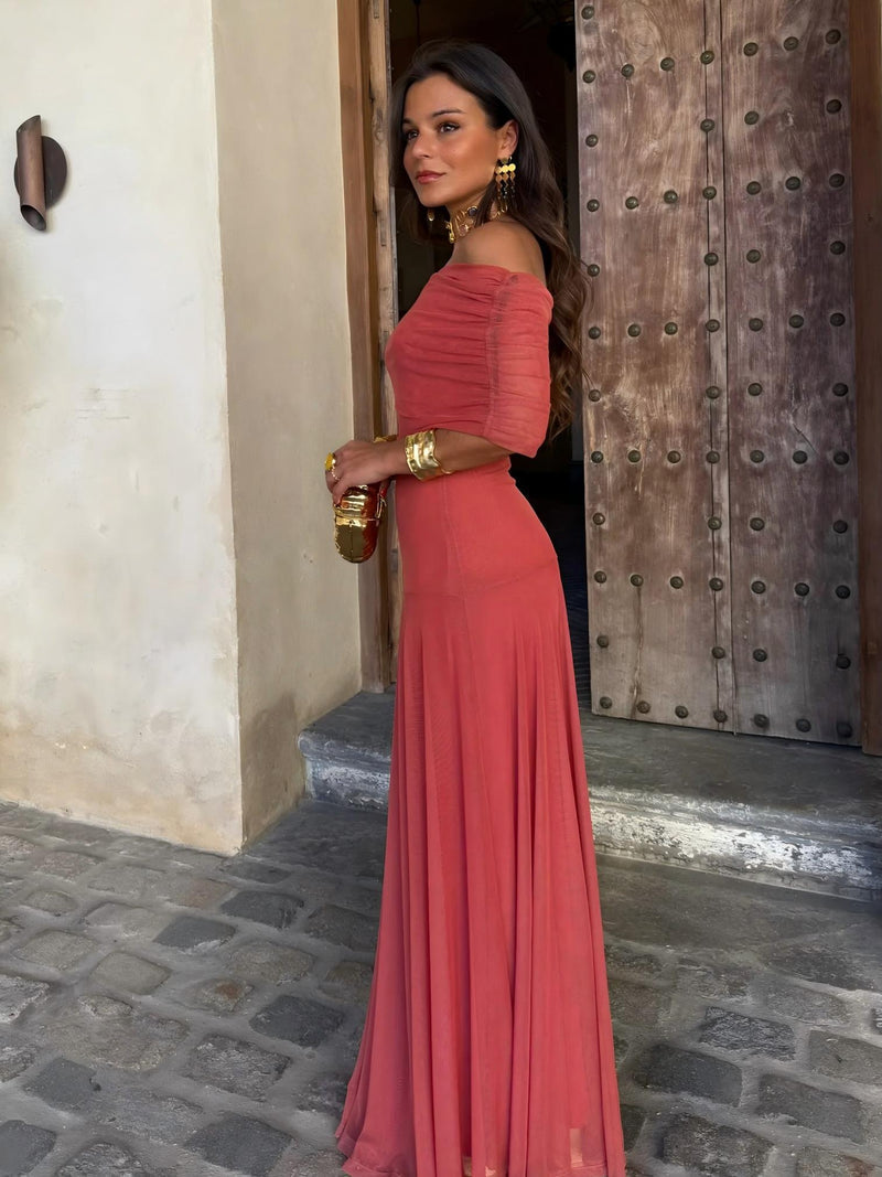 Terracotta dress worn off the shoulder with short ruched sleeves, shown in profile at a doorway 6