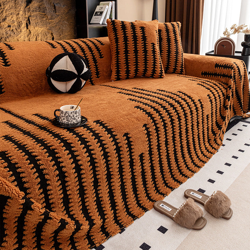 Burnt orange cover with black zigzag stripes on a sofa, with matching cushions and a teacup 12