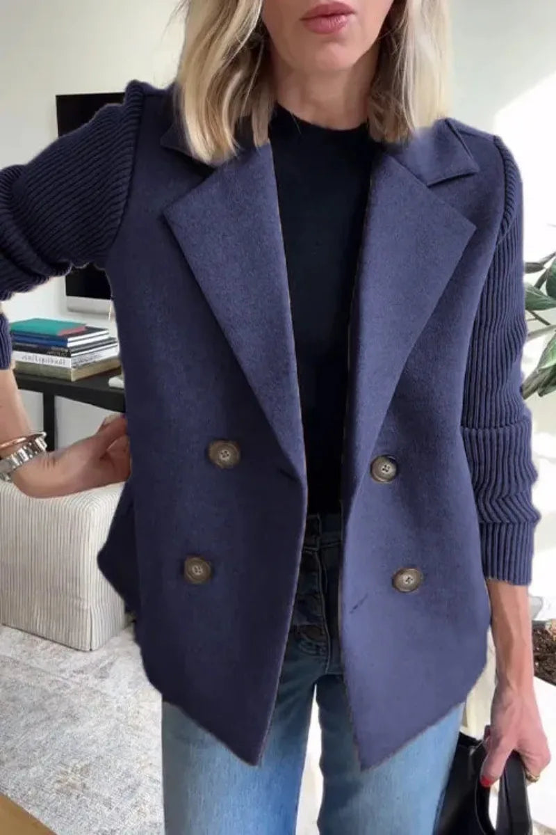 Close-up of navy double-breasted jacket on model, showing wide lapels, buttons and ribbed sleeves 8