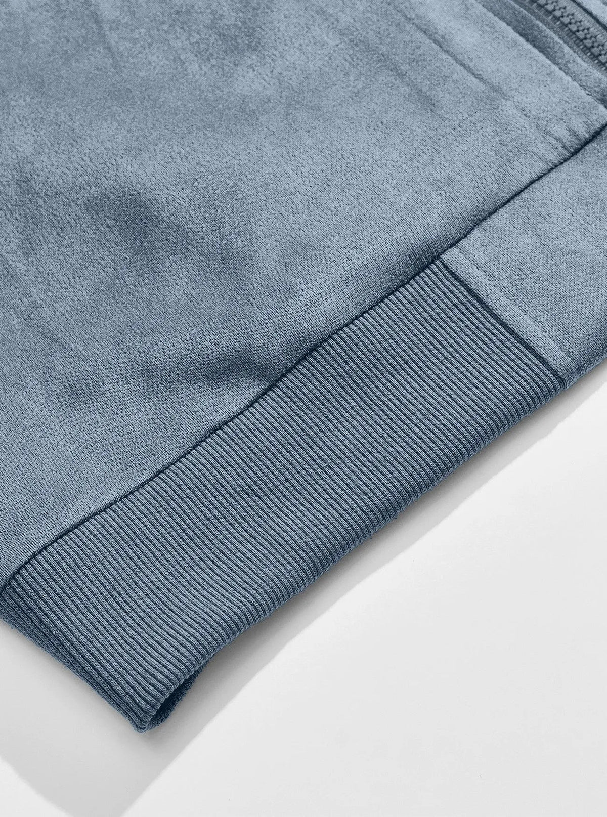 Close-up of the ribbed bottom hem on the soft light blue suede-look fabric 8