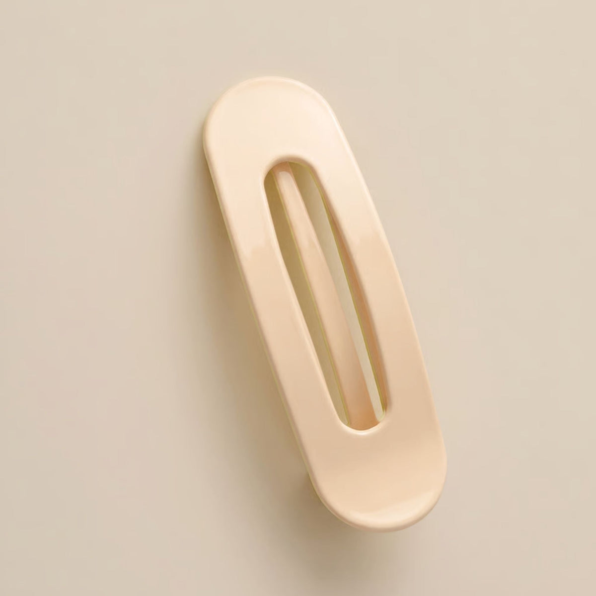 Glossy cream-peach slim flat clip with a long open slot on a soft beige background 7