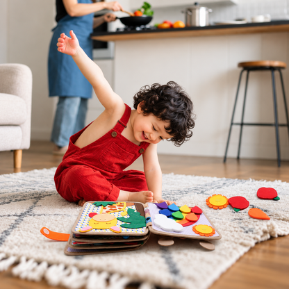 Toddler in red dungarees sitting on a rug, playing with the open giraffe book and felt pieces 9