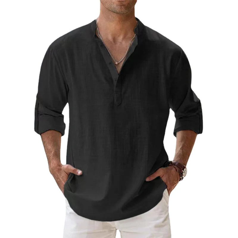 Man wearing the Henley shirt in black, with a short button placket, rolled sleeves and hands in white trouser pockets. 7