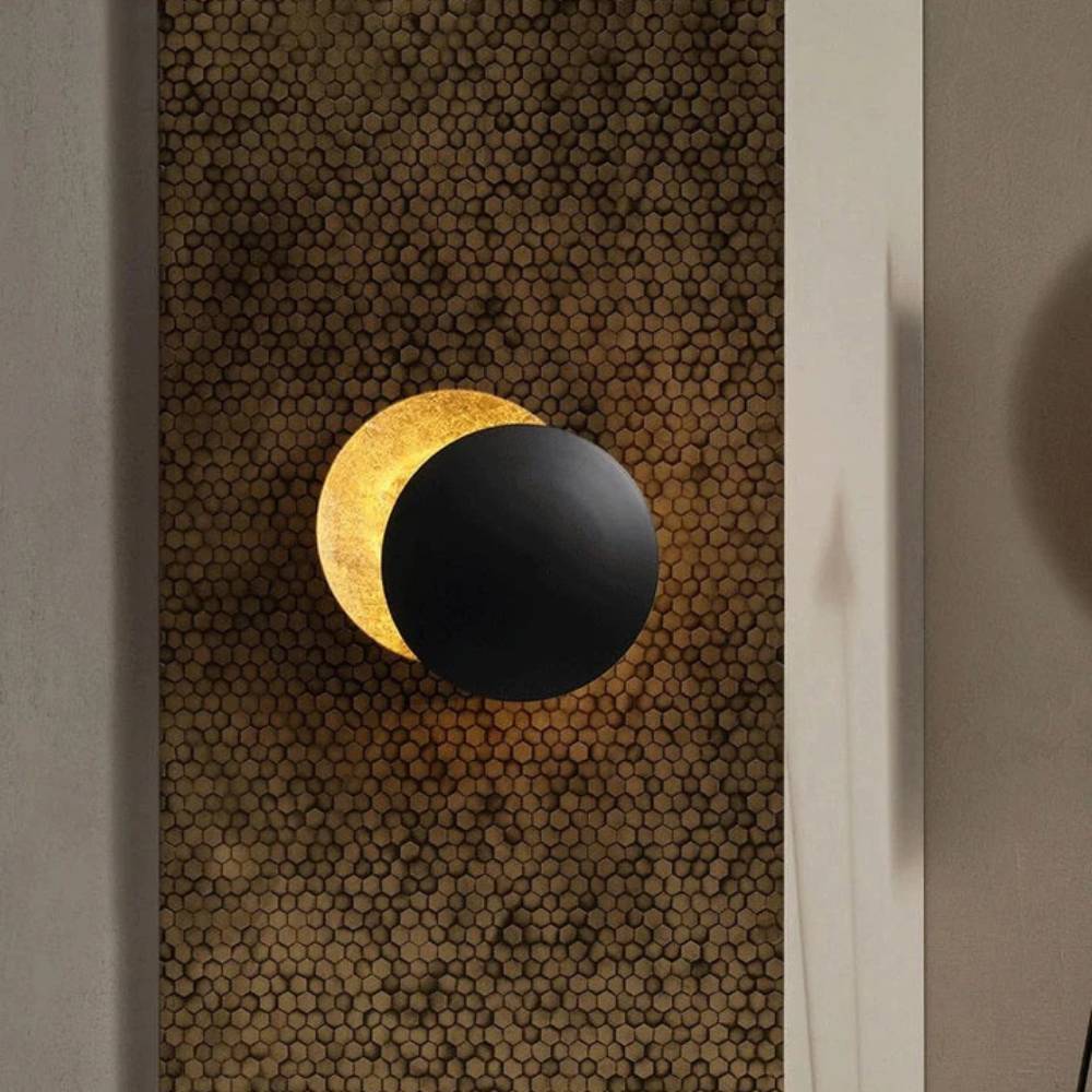 Black front disc with glowing gold crescent behind, mounted on a honeycomb-patterned wall panel 2