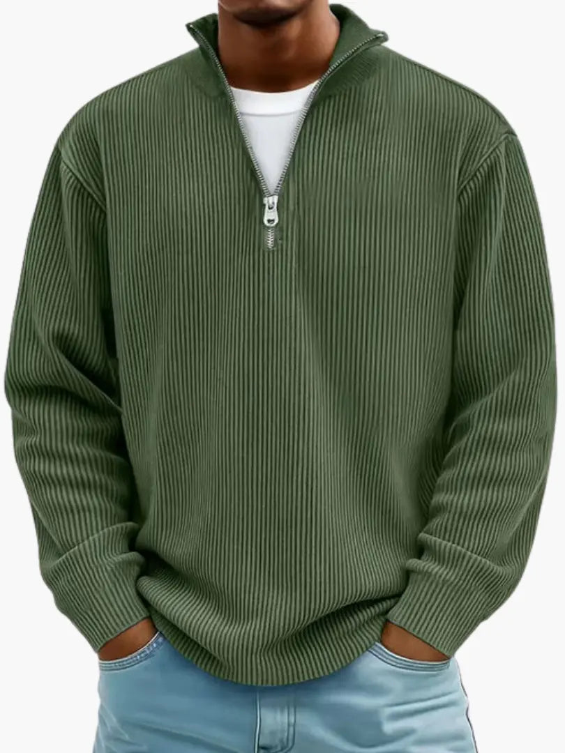 Man wearing the ribbed quarter-zip jumper in dark olive green over a white tee, with light blue jeans. 8