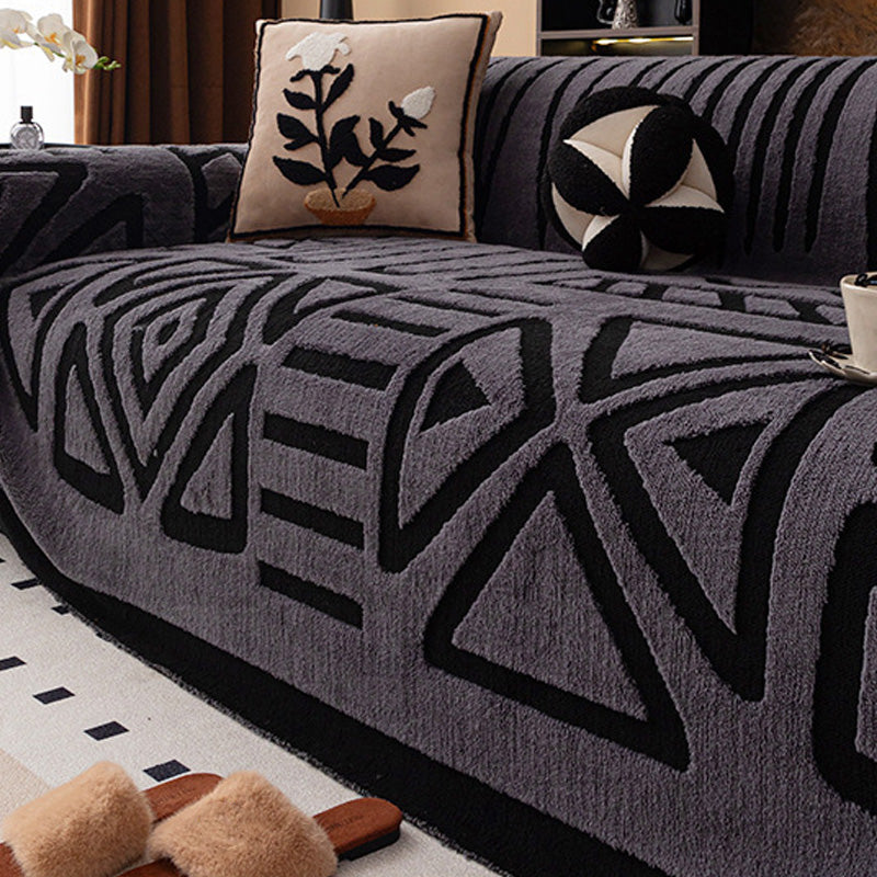 Darker charcoal cover with black geometric triangle and diamond pattern, with a plant-motif cushion and slippers 16