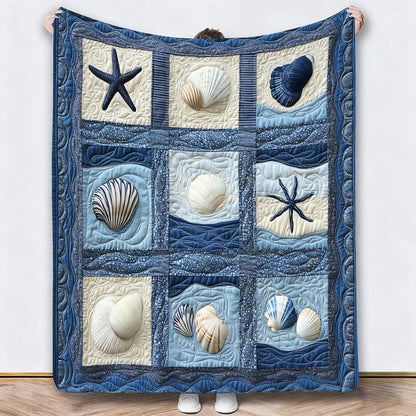 Person holding up a different blanket with blue and cream seashell and starfish squares 5