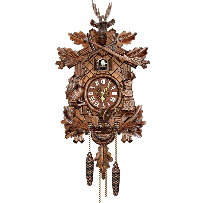 Traditional carved cuckoo clock with stag head, crossed rifles, oak leaves, bird and hare carvings, Roman numeral dial and two cone weights. 10