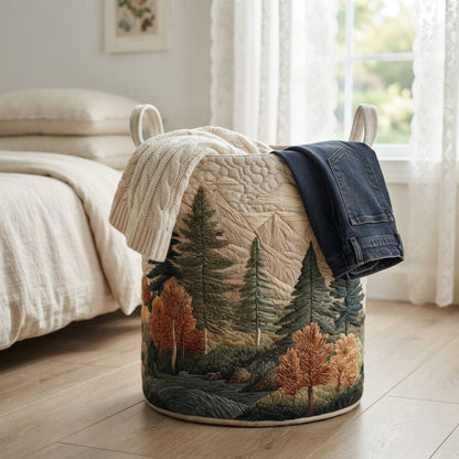 Forest-print quilted basket in a bedroom, with a cream knitted jumper and dark jeans draped over the rim. 13