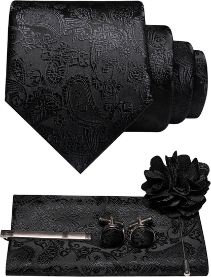 All-black paisley tie set flat lay with tonal pattern, pocket square, tie clip, cufflinks and flower lapel brooch. 37