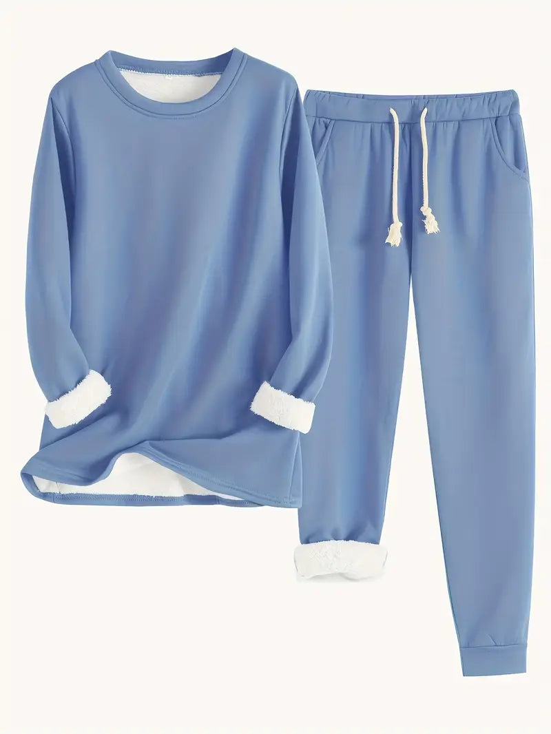 Flat lay of the sweatshirt and joggers in dusty blue, with white fleece showing at cuffs and hem 1