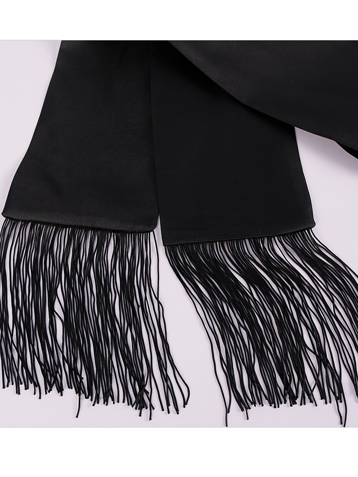Close-up of the black satin sash with long fringed tassels at both ends 8