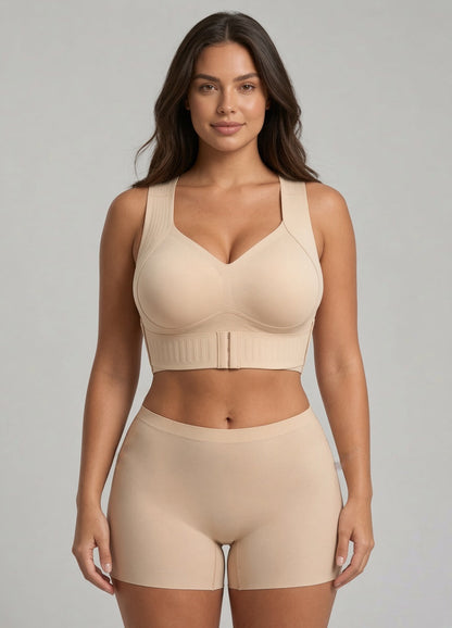 Model facing forward in the beige V-neck bra with wide straps and front hook closure, with matching shorts. 1