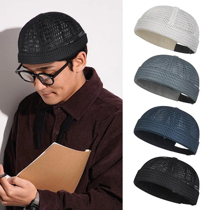 Man in glasses and a brown shirt wearing the black cap, beside four colour variants 9